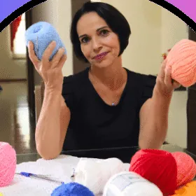 Neusa Souza segurando novelos de linha coloridos